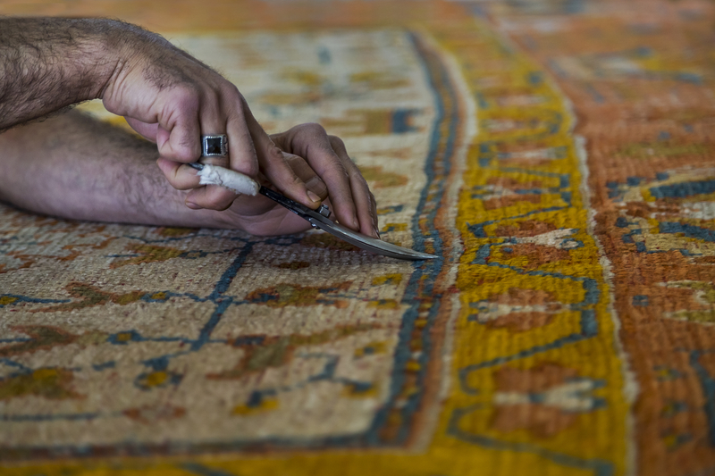 Cutting the fuzz of the carpet after it is restored