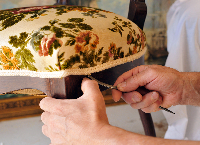 Renovation of an antique chair upholstery, upholsterer working.
